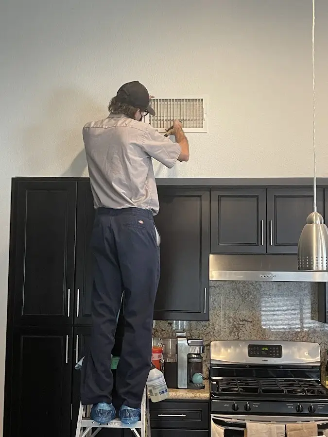 Technician inspecting an air vent during HVAC service in Villa Park
